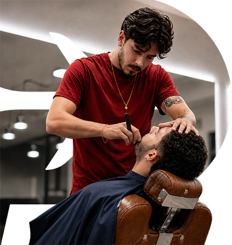 Barbeiro atendendo cliente em cadeira de barbearia
